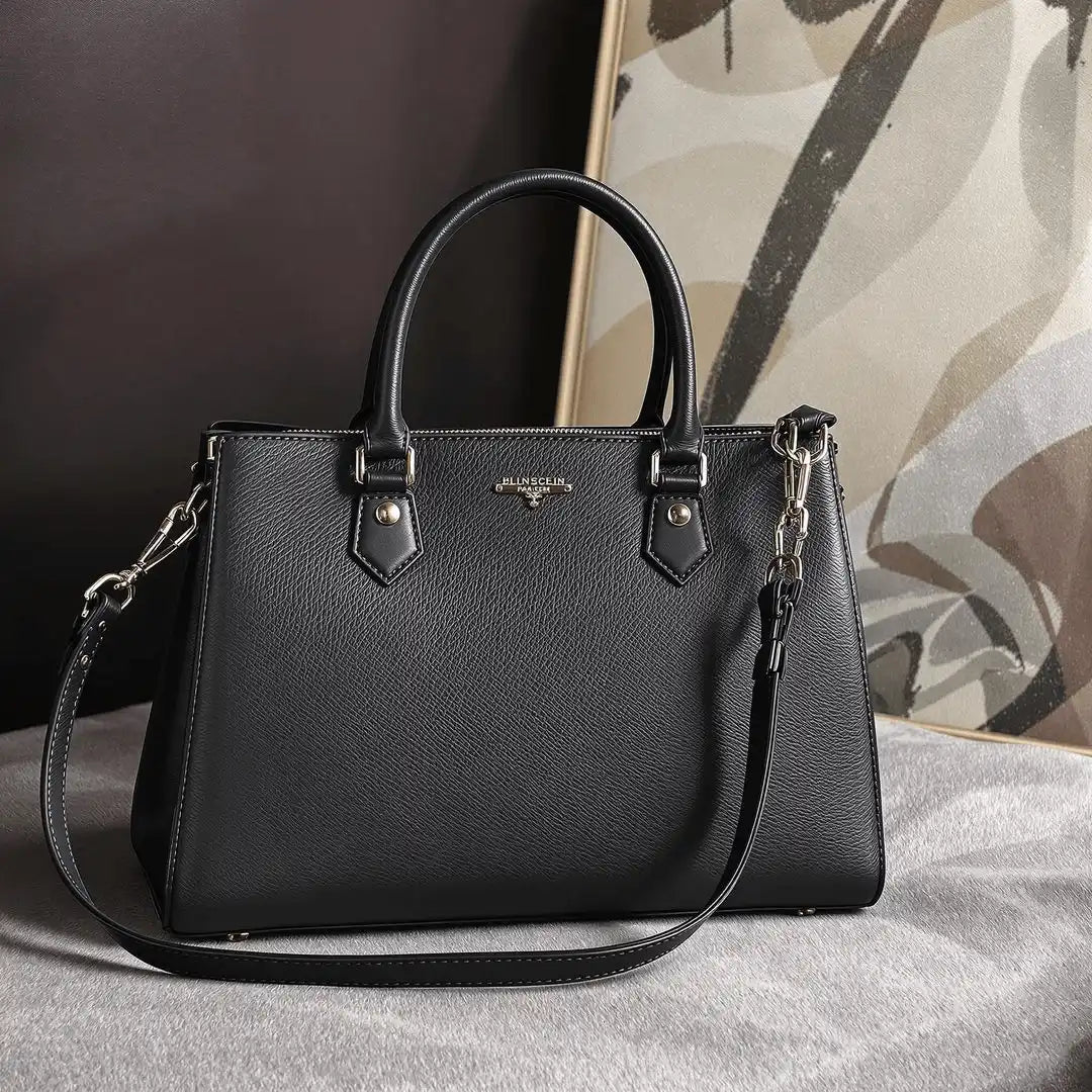 Black leather handbag with silver hardware and dual handles.